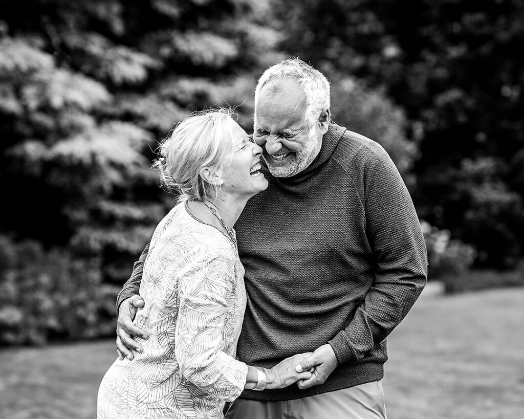 Couple from extended family laughing together during outdoor family photo session near Collingwood Ontario